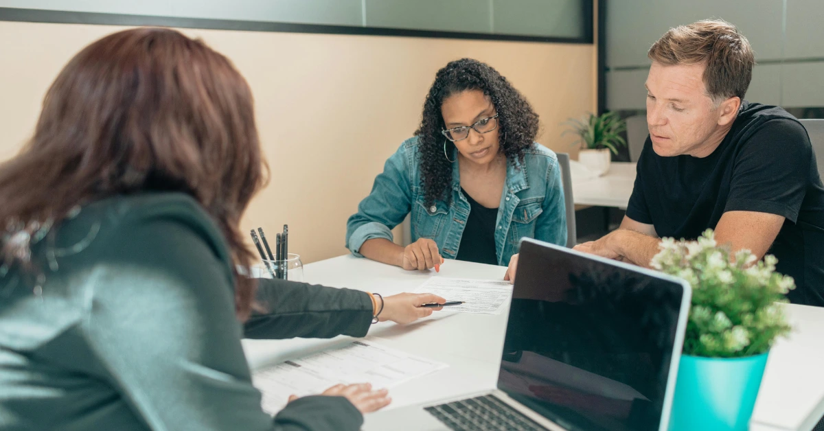 A Couple Talking to a Real Estate Agent in Office