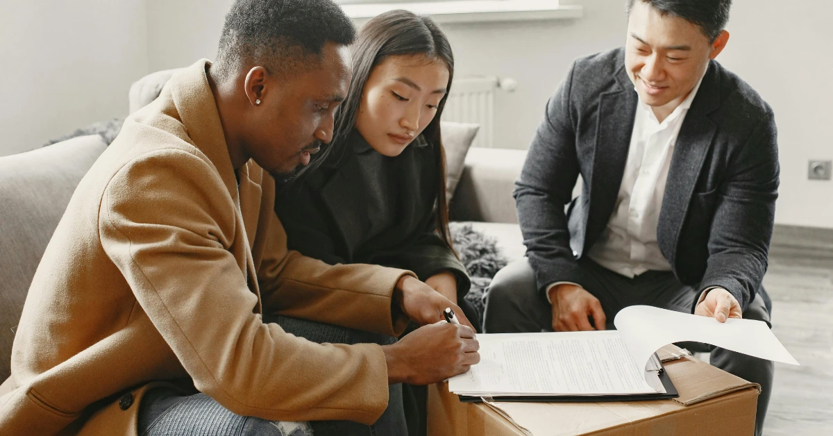 Couple Sitting on the Couch Signing a Contract