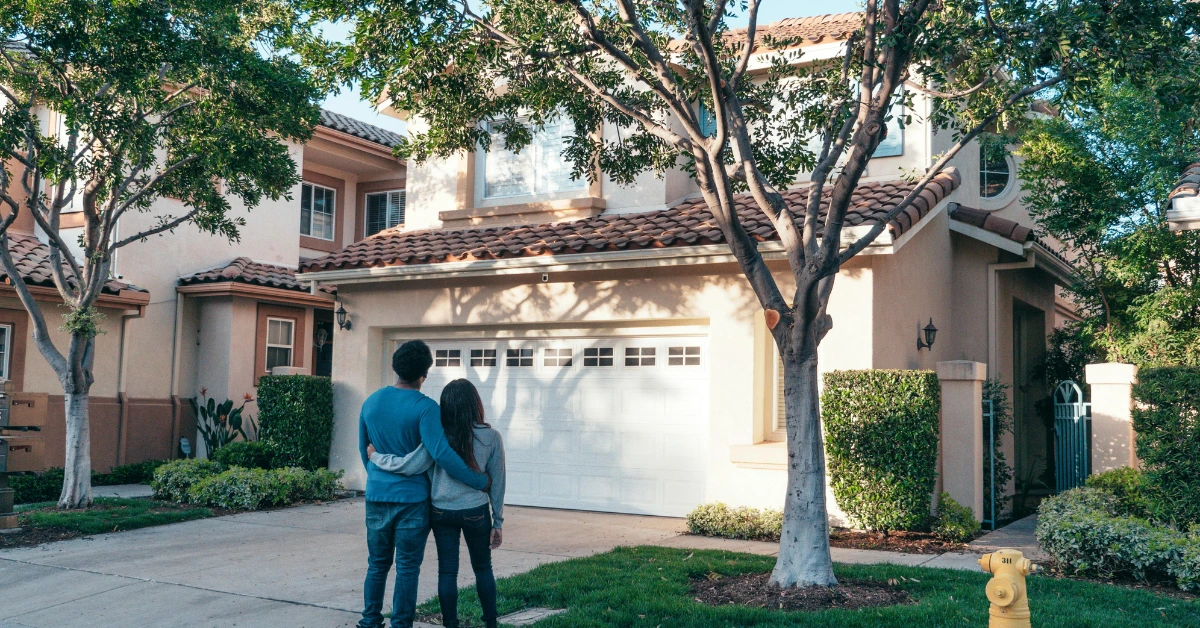 Couple Standing In Front of their House