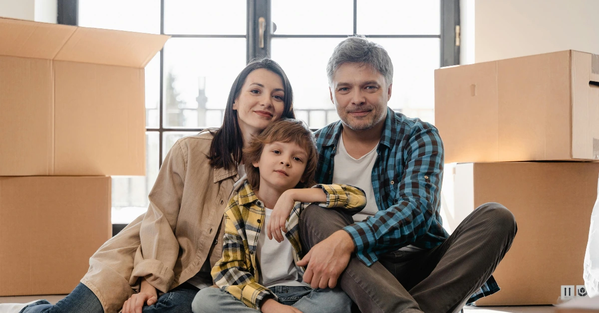 Family Sitting on the Floor Between Carton Boxes