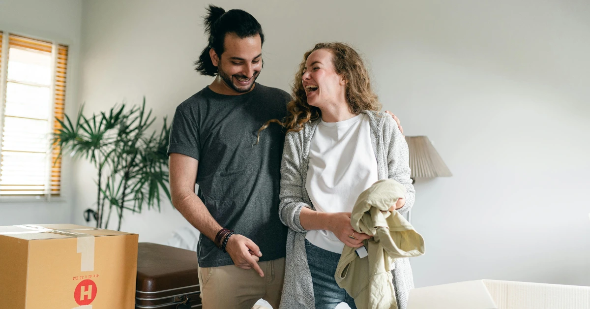 Happy Couple Unpacking Boxes in New Apartment