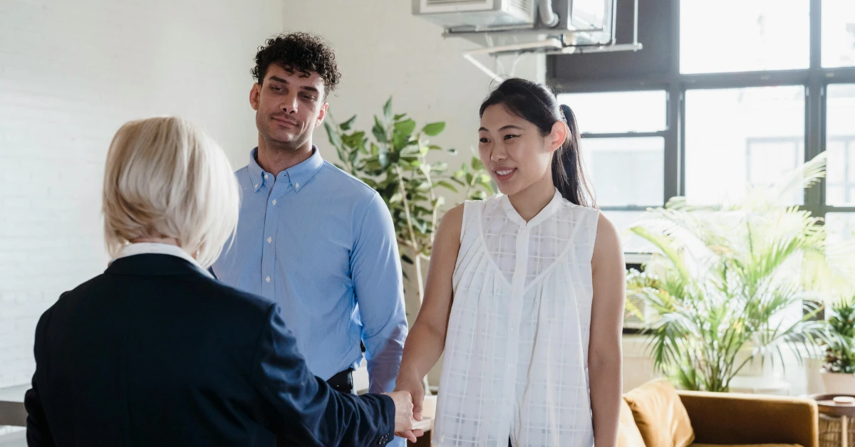 Real Estate Agent Shaking Hands of a Young Couple in Their New Flat